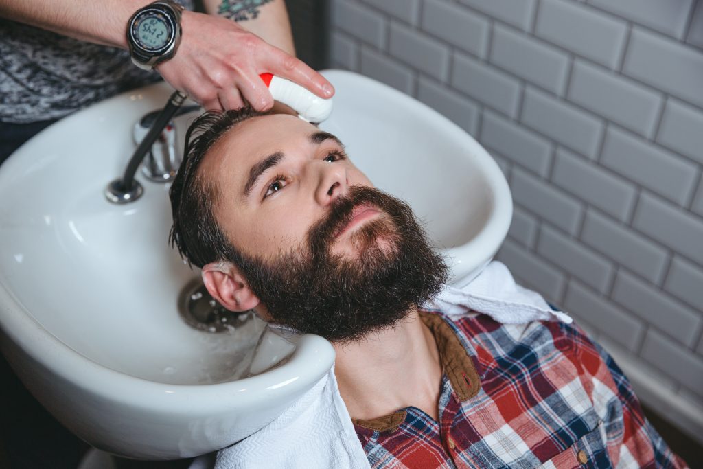 Man getting hairwash by hairdresser in hair salon